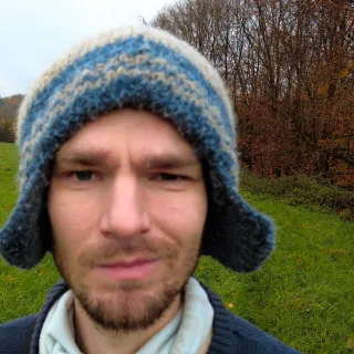 Portrait of Thomas Sommer, standing on a field in autumn