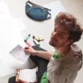 Rollgut Founder Thomas Sommer sitting on the floor, surrounded with papers and writing utensils, engaged in creative work using Rollgut